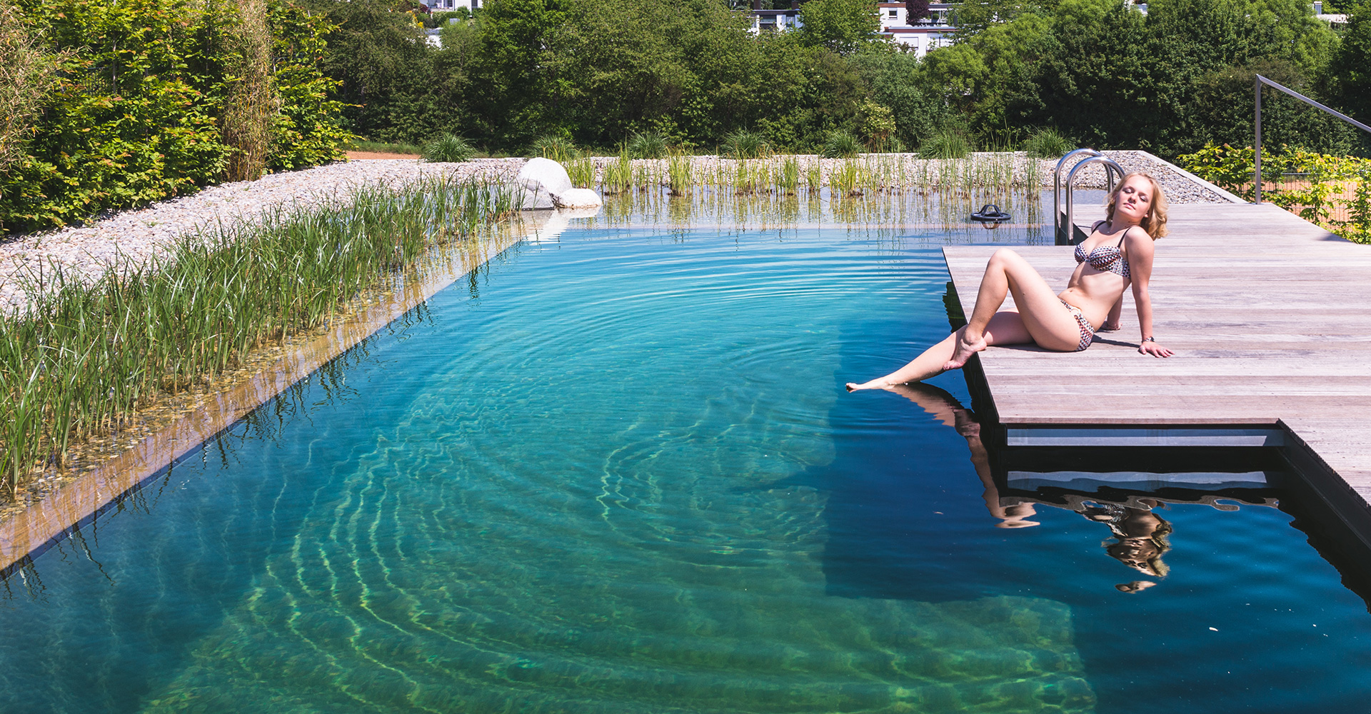 Frau sonnt sich am Bio-Schwimmbad